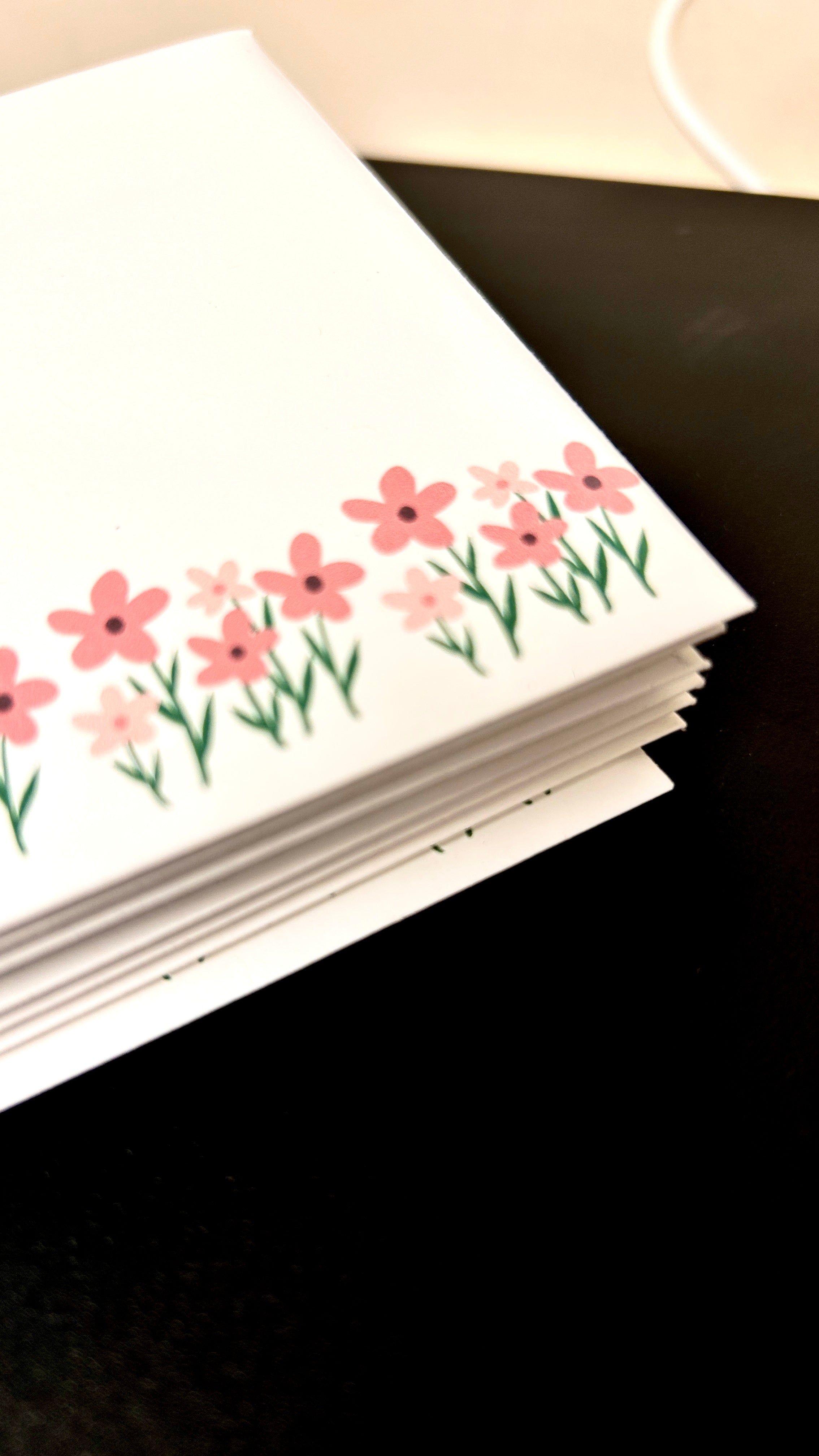 Stack of cards with floral design on a dark surface