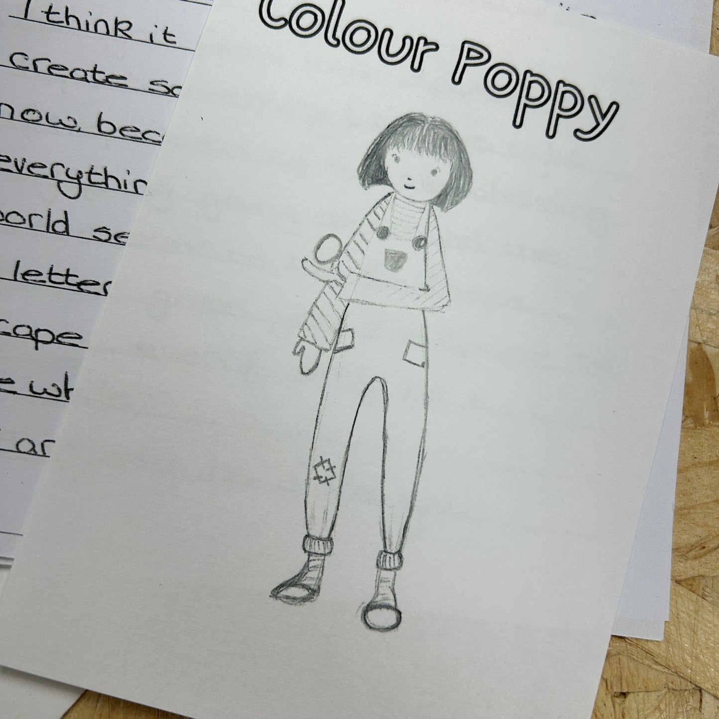 Black and white drawing of a person labeled 'Colour Poppy' on a piece of paper.