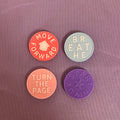 Four circular motivational stickers arranged in a 2x2 grid on a textured mauve background. The top-left sticker is coral orange with the text 'MOVE FORWARD' and a house icon.