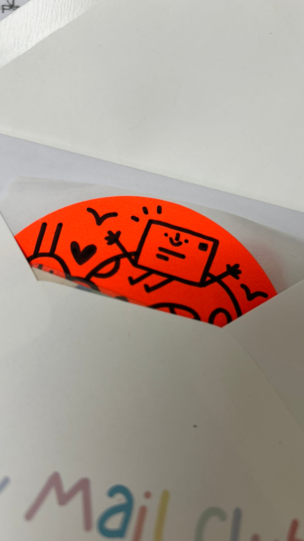 Orange sticker with cartoon design on a white envelope