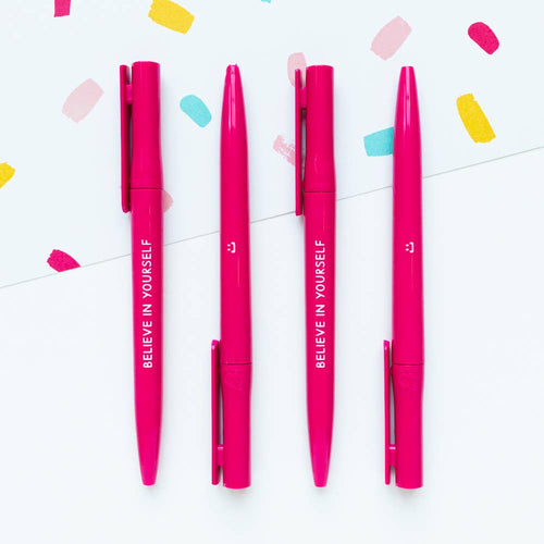 Pink pens with 'BELIEVE IN YOURSELF' text on a white background with colorful confetti.